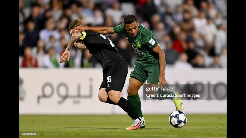 Cầu thủ của Beijing Guoan vượt qua hậu vệ của Macarthur FC trong trận đấu bóng đá