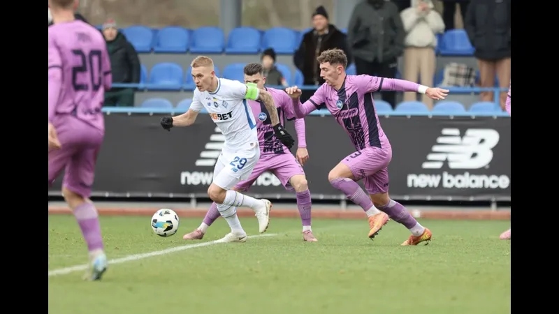 Cầu thủ của SC Poltava chạy nhanh với bóng trước sự truy đuổi của cầu thủ Epitsentr